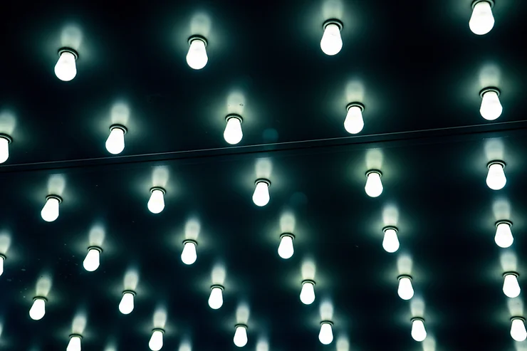 An array of illuminated oval lights set against a dark background, with a horizontal line crossing near the top, creating a modern, patterned display.